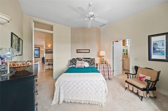 bedroom featuring ceiling fan, ensuite bathroom, and light colored carpet