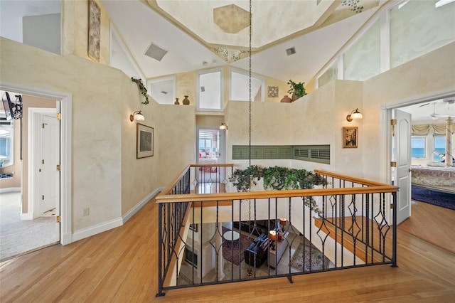 hallway featuring high vaulted ceiling and hardwood / wood-style floors