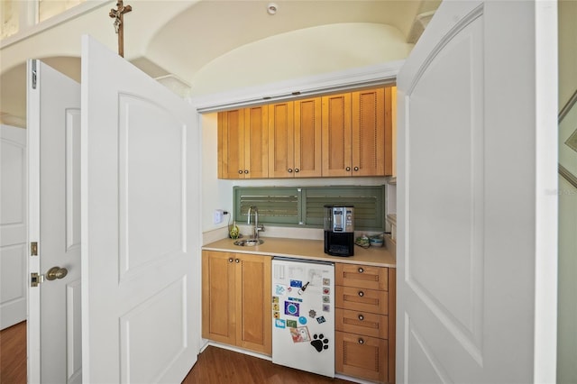 bar featuring dark wood-type flooring, sink, and fridge