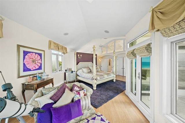 bedroom featuring vaulted ceiling, ornate columns, access to exterior, and hardwood / wood-style flooring