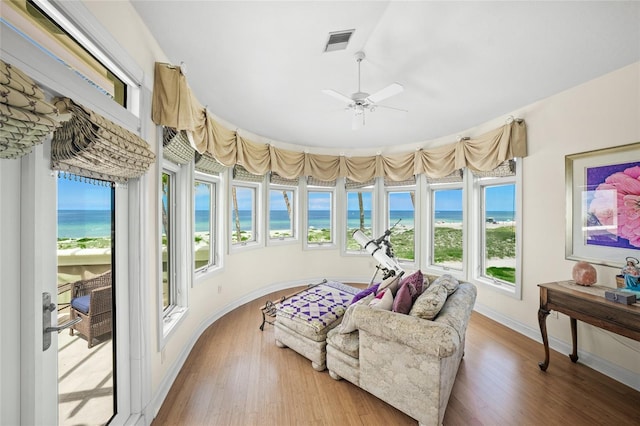 sunroom / solarium featuring a water view and ceiling fan