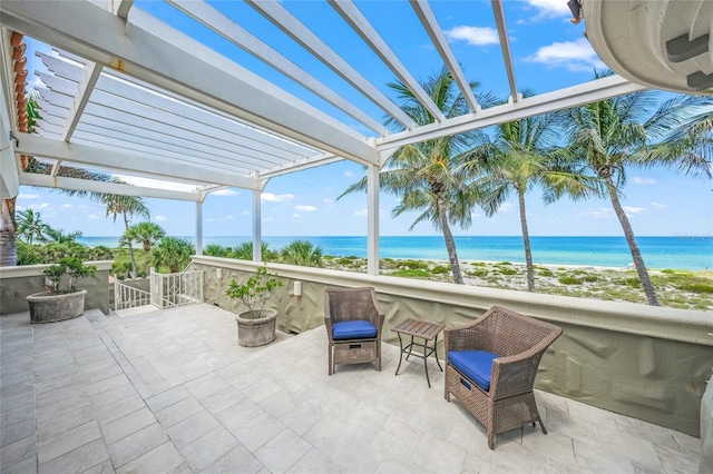 sunroom featuring a water view and a view of the beach