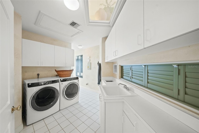 clothes washing area with sink, light tile patterned floors, cabinets, and separate washer and dryer