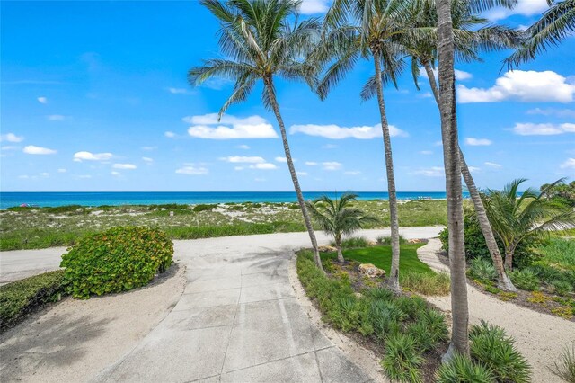 view of home's community featuring a water view and a beach view