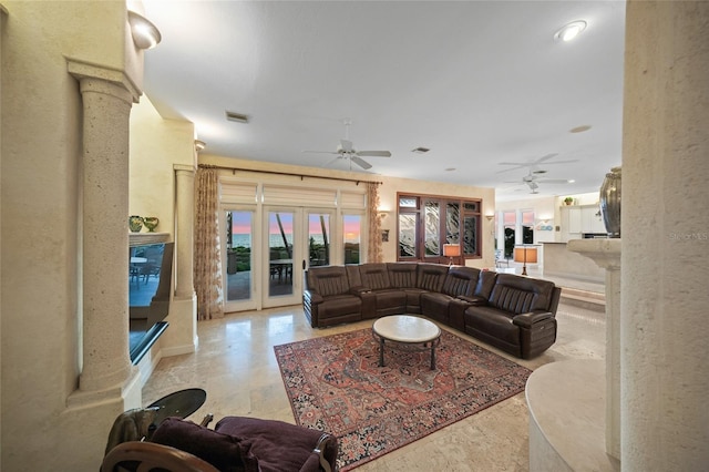 living room featuring decorative columns, ceiling fan, and french doors