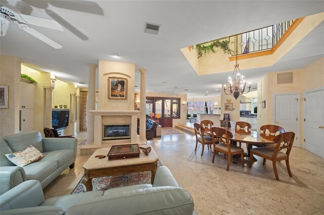 living room featuring a premium fireplace and ceiling fan with notable chandelier