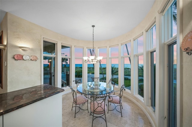 dining space with a water view and a chandelier