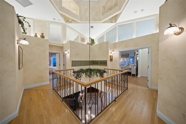 hallway featuring hardwood / wood-style flooring and a towering ceiling