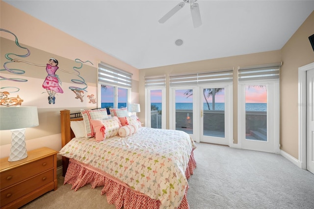 carpeted bedroom featuring ceiling fan, multiple windows, access to outside, and a water view