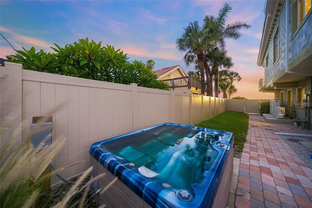 patio terrace at dusk with a hot tub