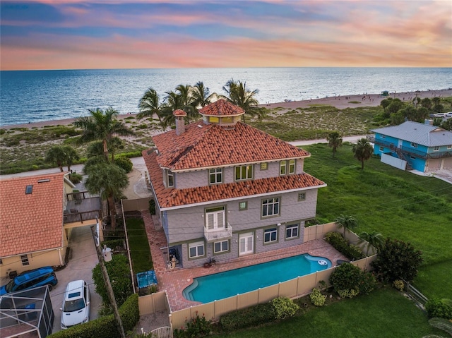 aerial view at dusk featuring a water view