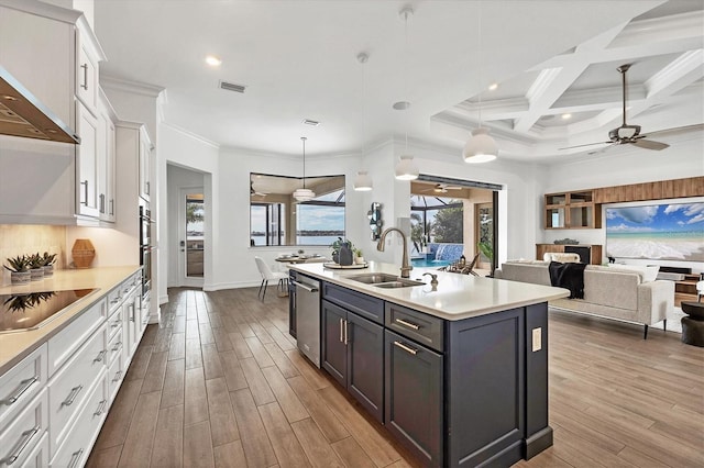 kitchen featuring sink, white cabinetry, stainless steel appliances, and an island with sink