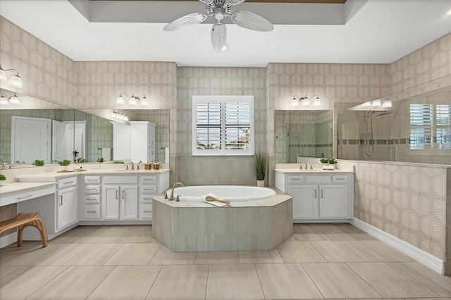 bathroom with a garden tub, two vanities, walk in shower, and wallpapered walls