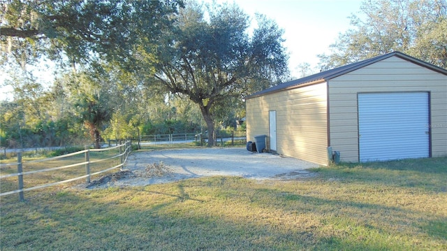 view of yard featuring a garage and an outbuilding