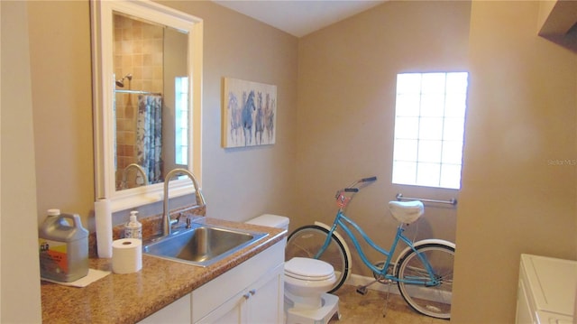 bathroom with toilet, vanity, and walk in shower