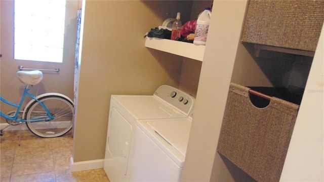 laundry room featuring washing machine and dryer and light tile patterned flooring