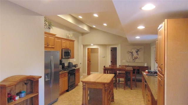 kitchen with appliances with stainless steel finishes and lofted ceiling