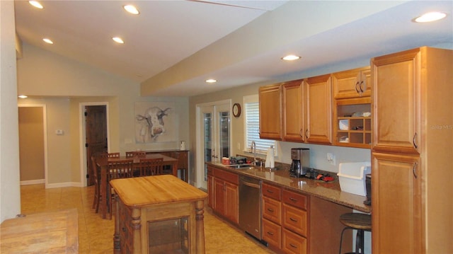 kitchen with light tile patterned floors, dark stone countertops, dishwasher, vaulted ceiling, and sink