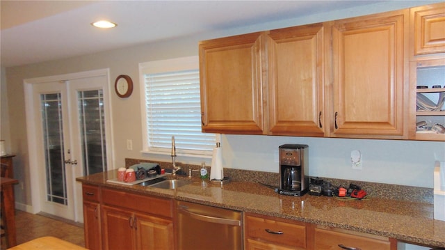 kitchen with stone counters, dishwasher, french doors, and sink