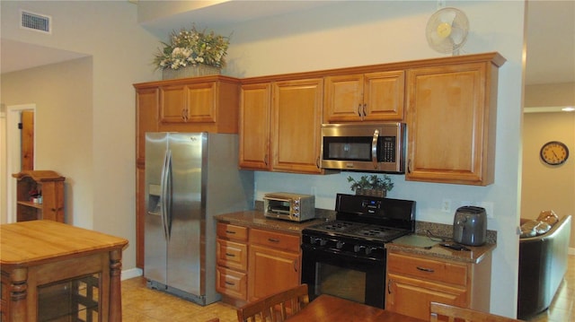 kitchen with stainless steel appliances and dark stone countertops