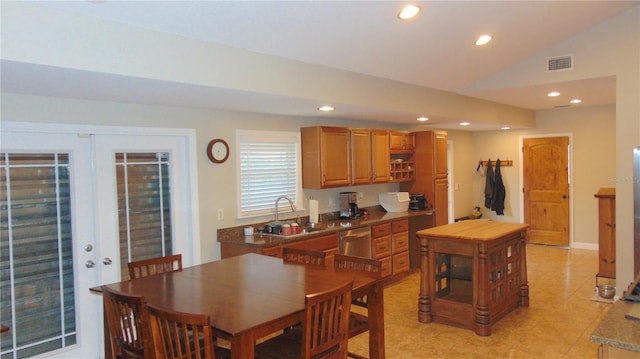 dining space with sink, light tile patterned floors, and lofted ceiling