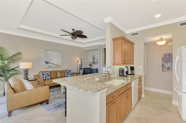 kitchen with kitchen peninsula, ceiling fan, white appliances, light brown cabinetry, and sink