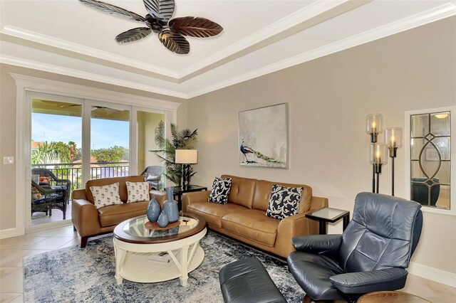 living room featuring a raised ceiling, light tile patterned floors, ceiling fan, and crown molding