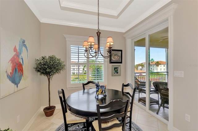 dining space with ornamental molding, a healthy amount of sunlight, a chandelier, and a raised ceiling