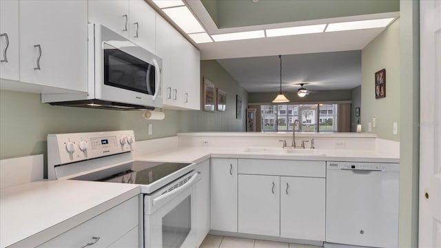 kitchen with hanging light fixtures, white cabinets, sink, and white appliances