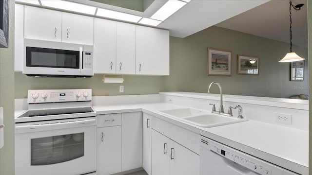 kitchen featuring pendant lighting, white appliances, white cabinets, sink, and kitchen peninsula