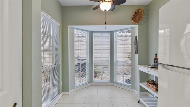 unfurnished dining area with ceiling fan, light tile patterned floors, and plenty of natural light