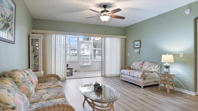 living room featuring ceiling fan and light hardwood / wood-style floors