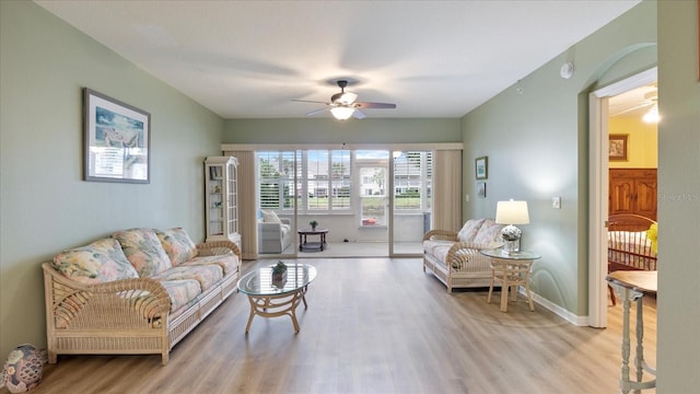 living room with ceiling fan and light hardwood / wood-style flooring