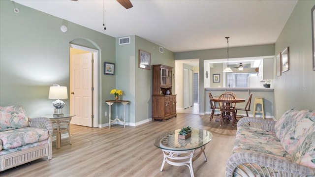 living room featuring ceiling fan and light hardwood / wood-style floors