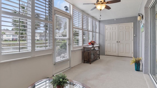 sunroom featuring ceiling fan and plenty of natural light