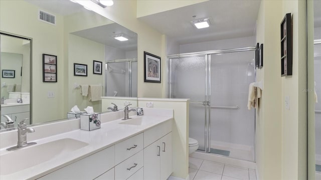 bathroom featuring walk in shower, vanity, tile patterned floors, and toilet