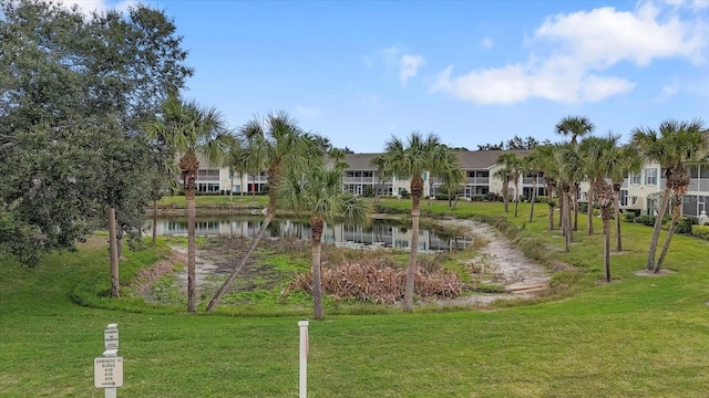 surrounding community featuring a water view and a lawn