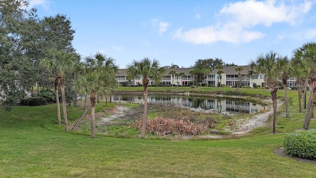 view of home's community with a water view and a yard