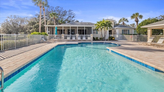 view of pool featuring a patio area and a sunroom