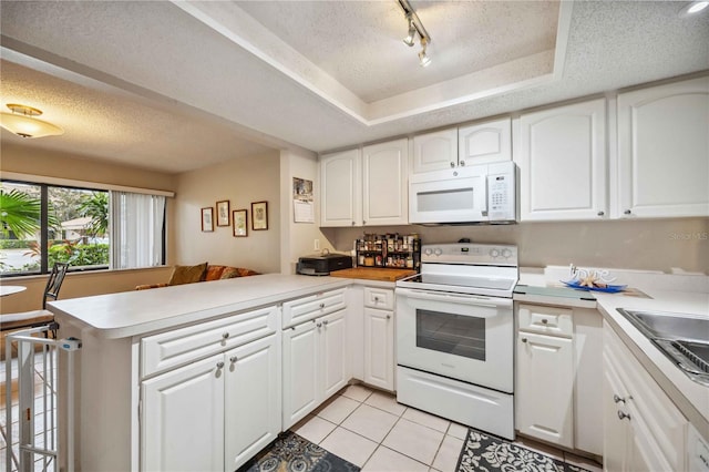 kitchen with white appliances, white cabinets, track lighting, kitchen peninsula, and light tile patterned flooring