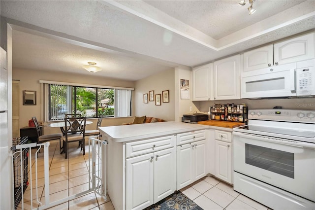 kitchen with white appliances, a textured ceiling, white cabinets, kitchen peninsula, and light tile patterned flooring