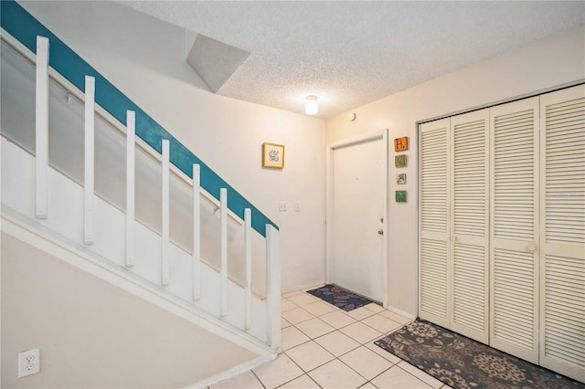 tiled foyer featuring a textured ceiling