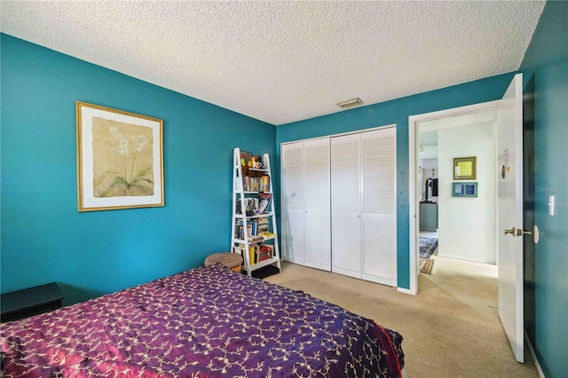 carpeted bedroom featuring a textured ceiling and a closet