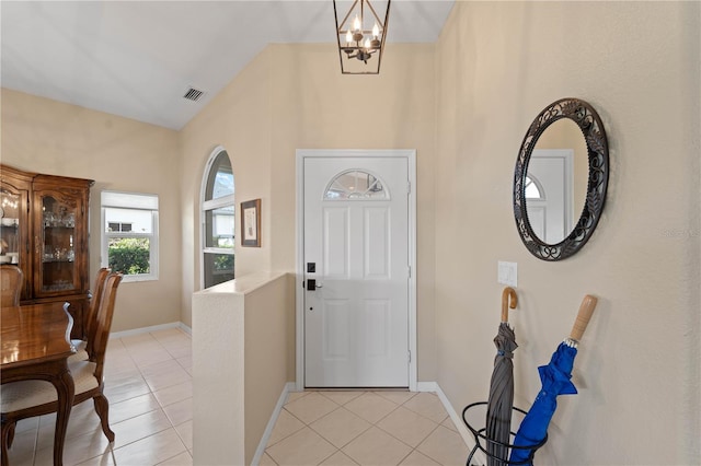 tiled entrance foyer with a notable chandelier