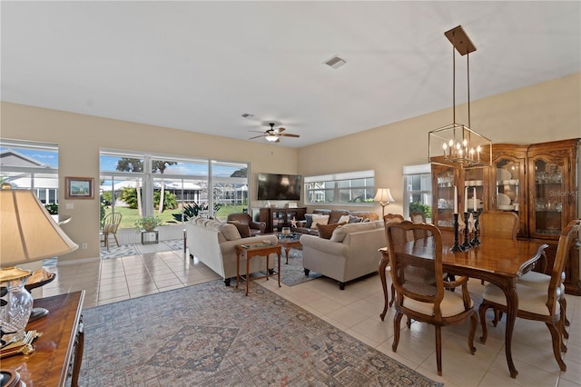 tiled dining space featuring ceiling fan with notable chandelier