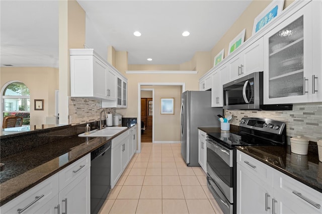 kitchen featuring dark stone countertops, decorative backsplash, sink, appliances with stainless steel finishes, and white cabinets