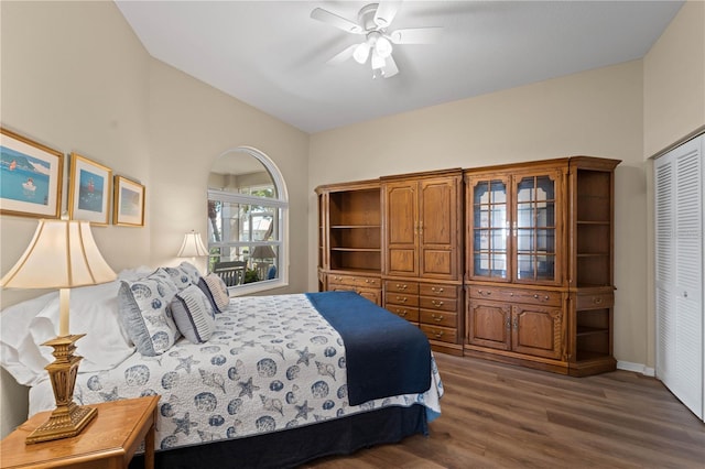 bedroom with ceiling fan, a closet, and dark wood-type flooring