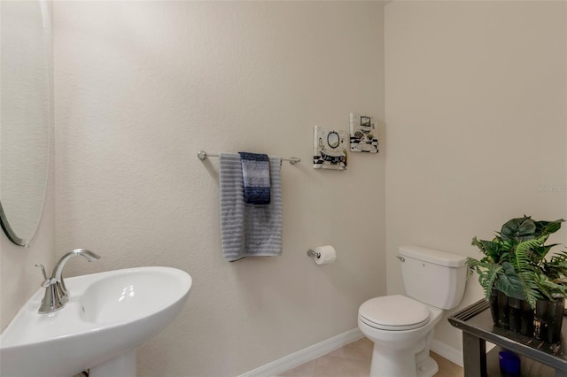 bathroom featuring sink, toilet, and tile patterned flooring