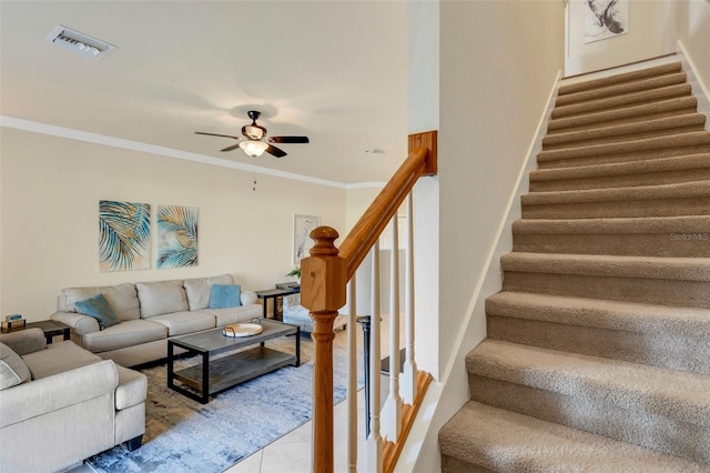 living room with crown molding, light tile patterned flooring, and ceiling fan