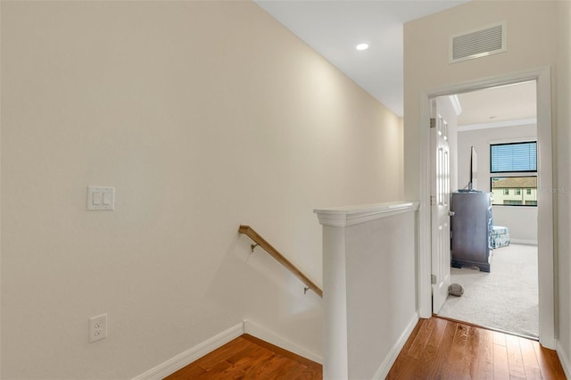 hallway with wood-type flooring and ornamental molding